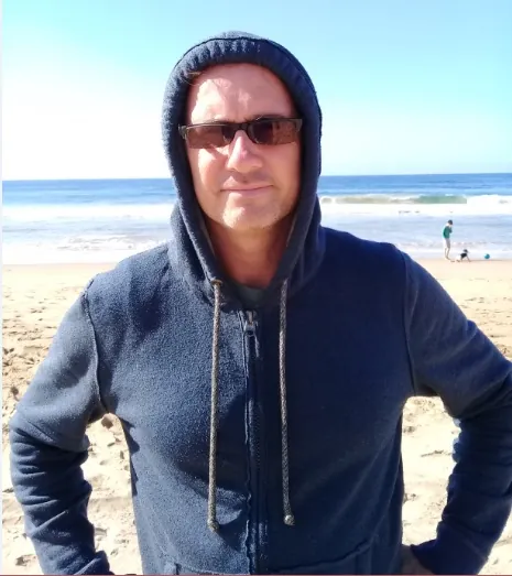 Richard Daguiar, onsite mentor at Godsolve, standing on the beach in Durban